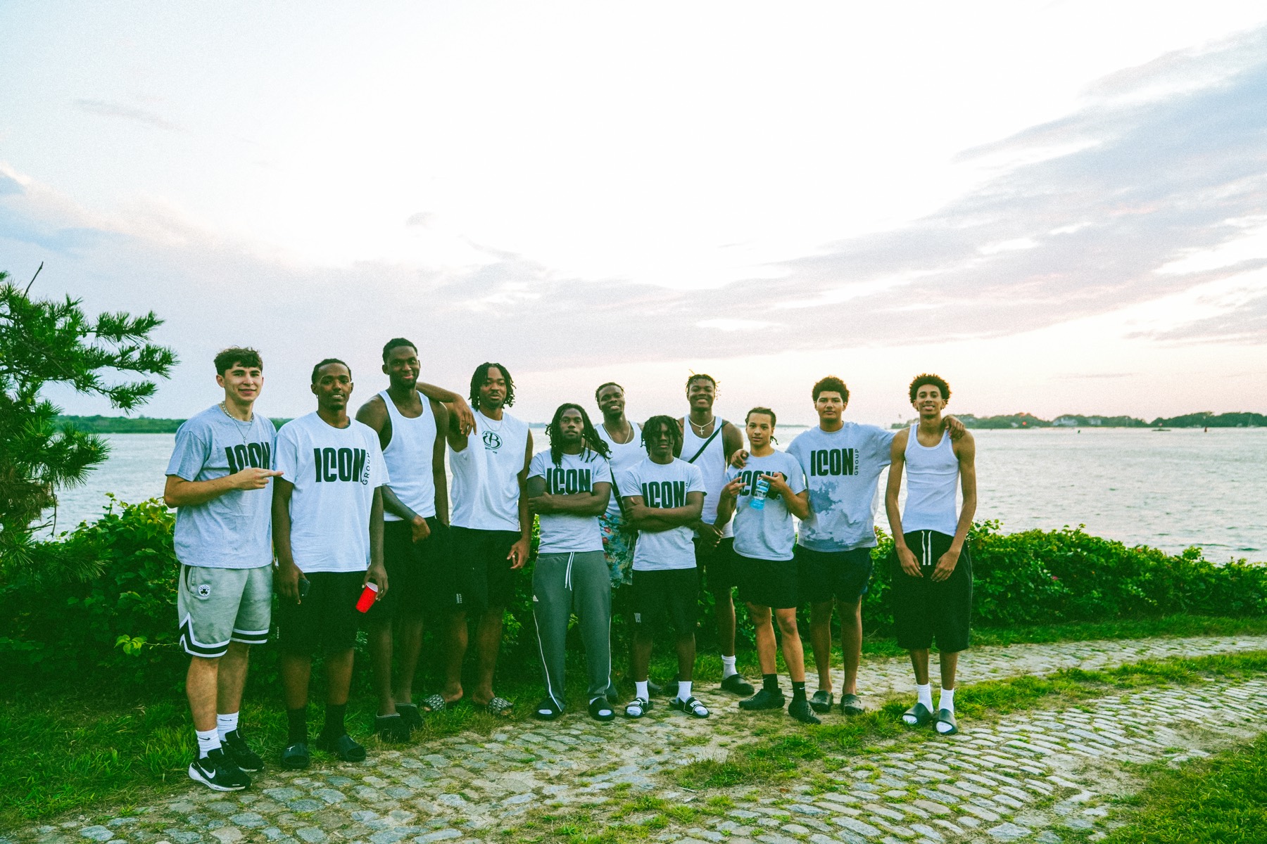 A team gathered at the water's edge at dusk